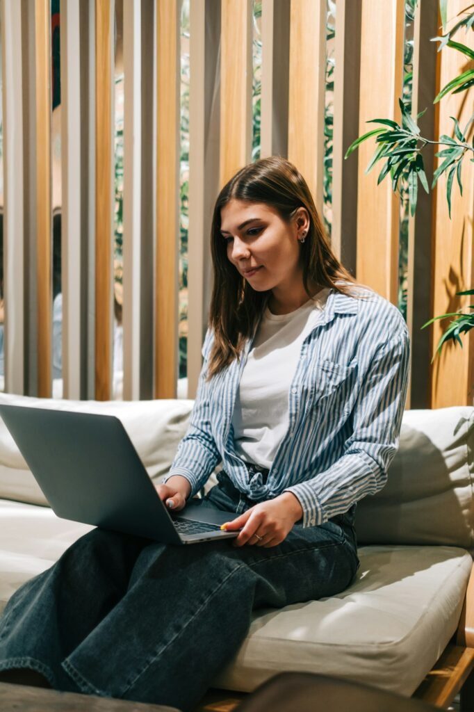 Young woman mobile developer with laptop, writes program code on a computer